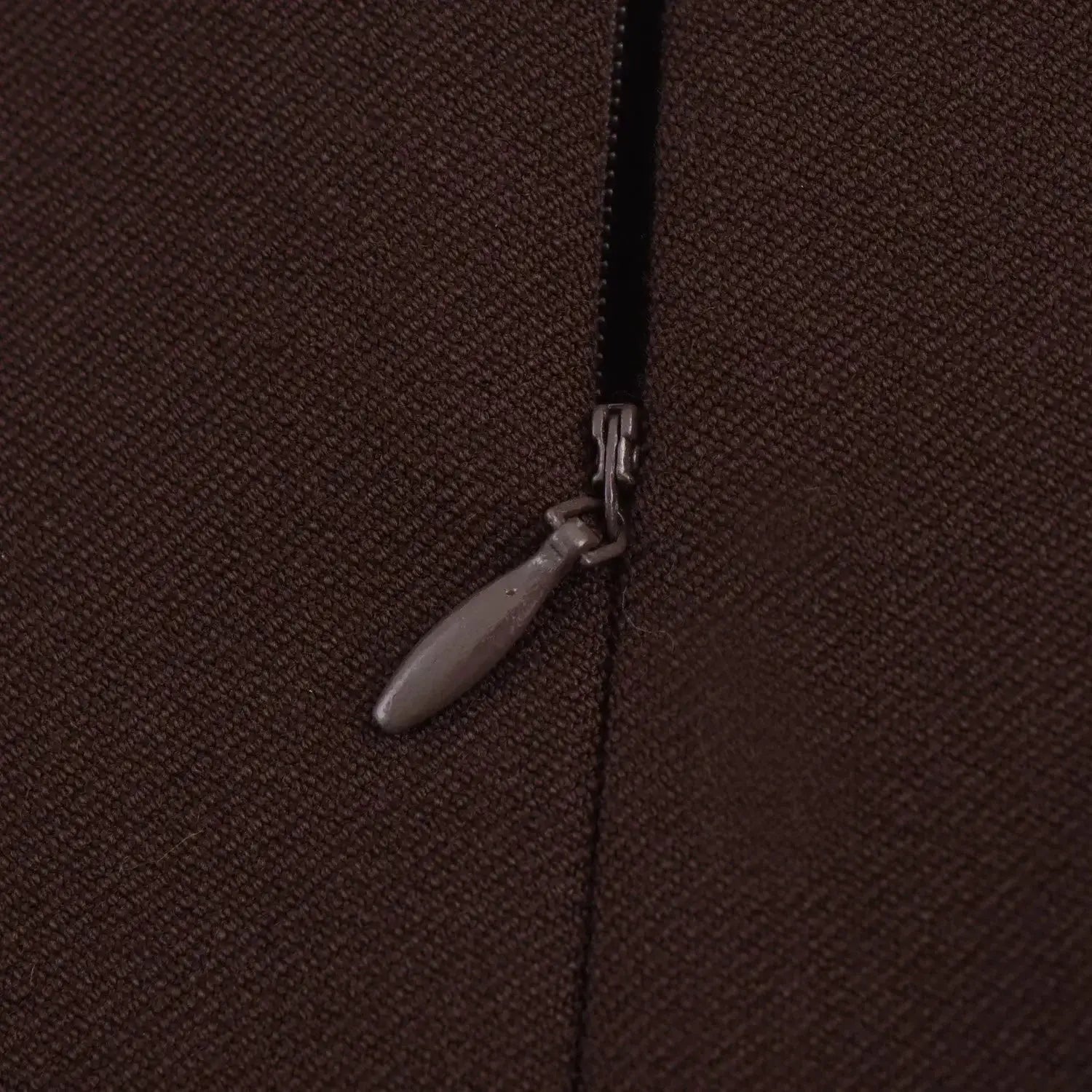 Brown textured blazer zipper close-up with metal pull on fabric