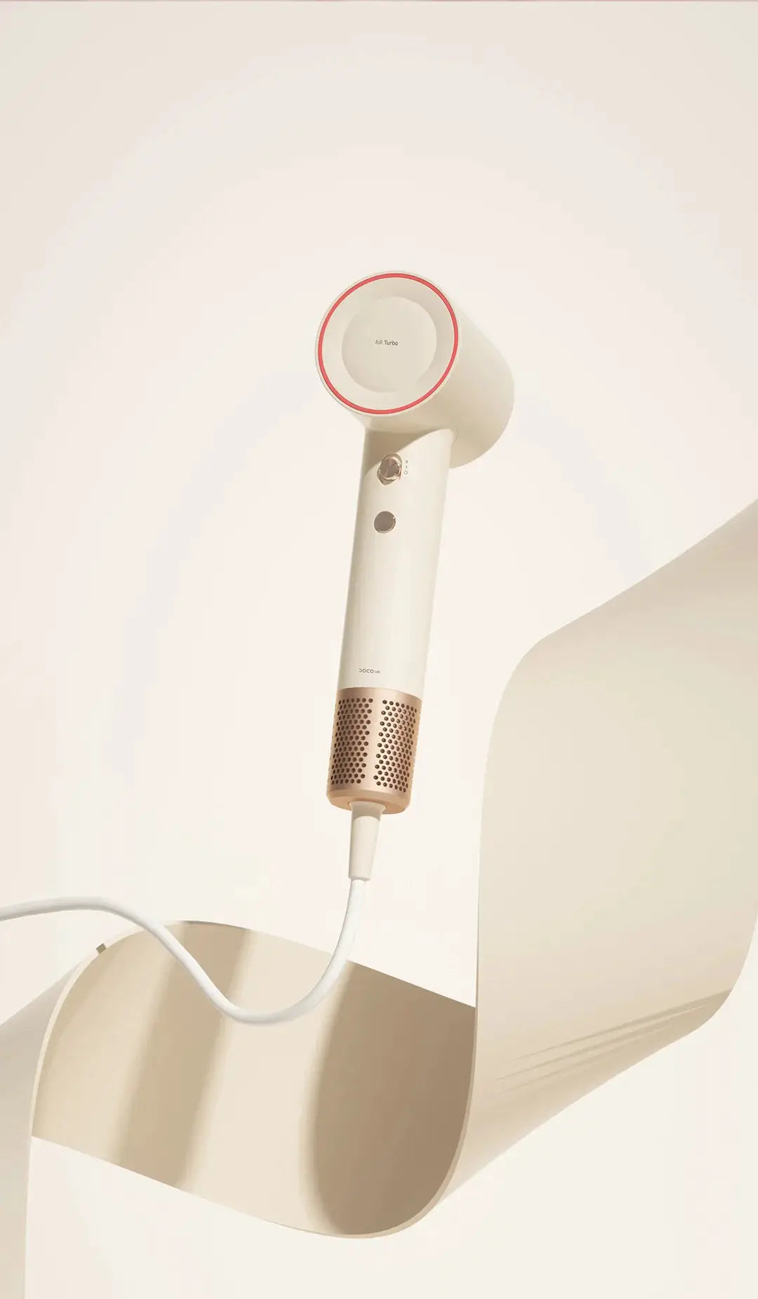 DOCO hair dryer in white with rose-gold accents, wall-mounted with circular head.