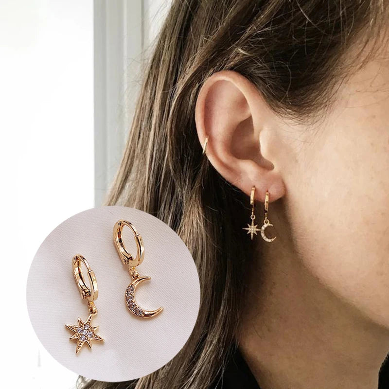 Gold-tone star and crescent moon dangle earrings pair with crystal accents