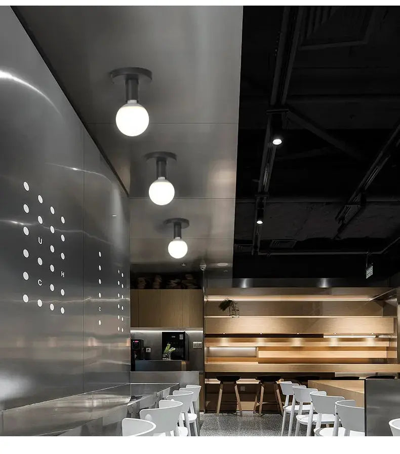 Minimalist black E27 ceiling light fixtures with iron finish in Nordic retro style above a modern cafe bar