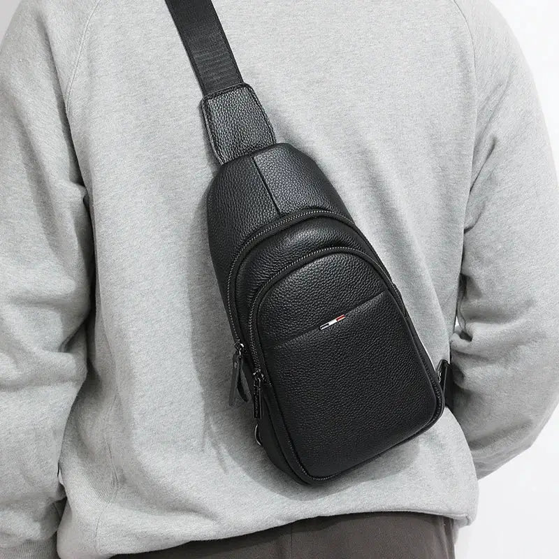 Simples Market black genuine leather chest bag with pebbled texture, front zip pocket and crossbody strap