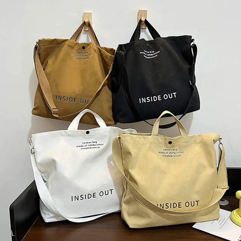 Set of four Simples Market canvas tote bags in brown, black, white and beige with INSIDE OUT print and long cross-body straps