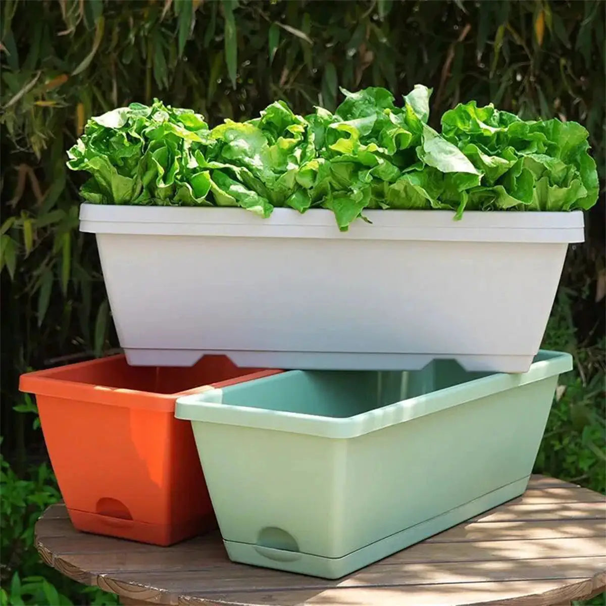 1-set of three plastic balcony planters with tray; white rectangular planter atop orange and mint-green troughs