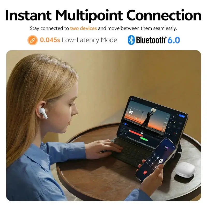 QCY T13 Pro wireless earbuds with adaptive ANC in white, worn by a person beside a tablet and smartphone on a table