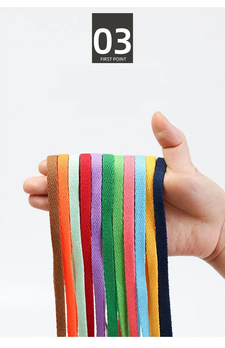 Flat shoelaces in assorted colors held in hand; versatile unisex casual and sports shoe laces.