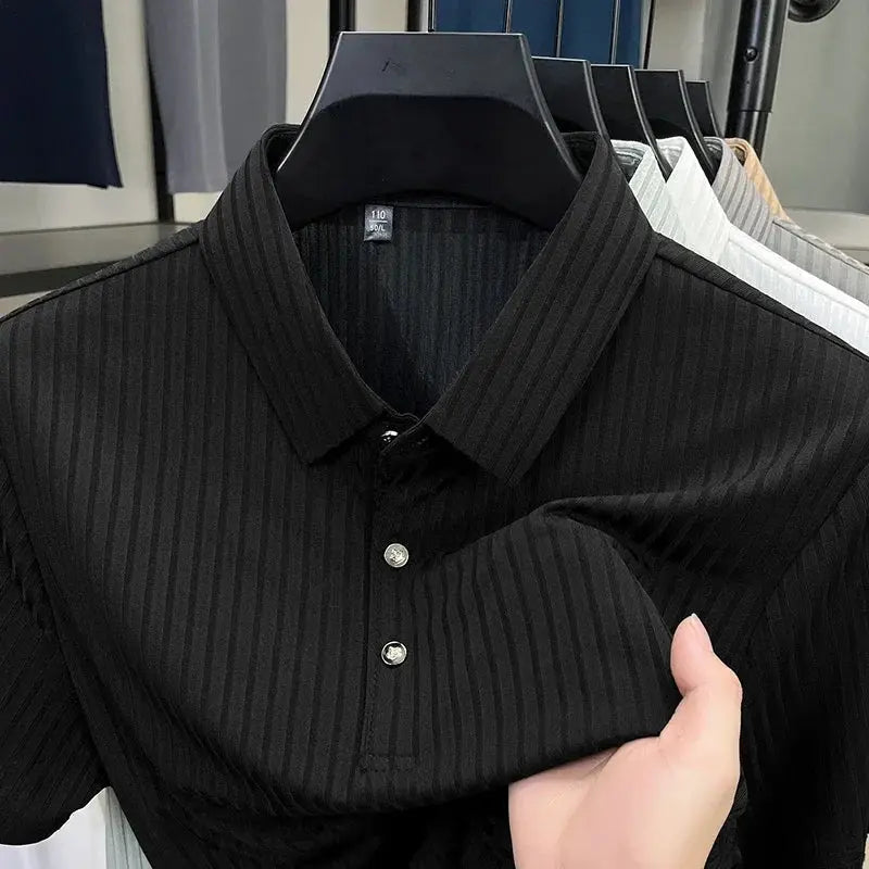 Polo shirt with collar, black pinstripe, short sleeves, on a hanger among several shirts on display in store