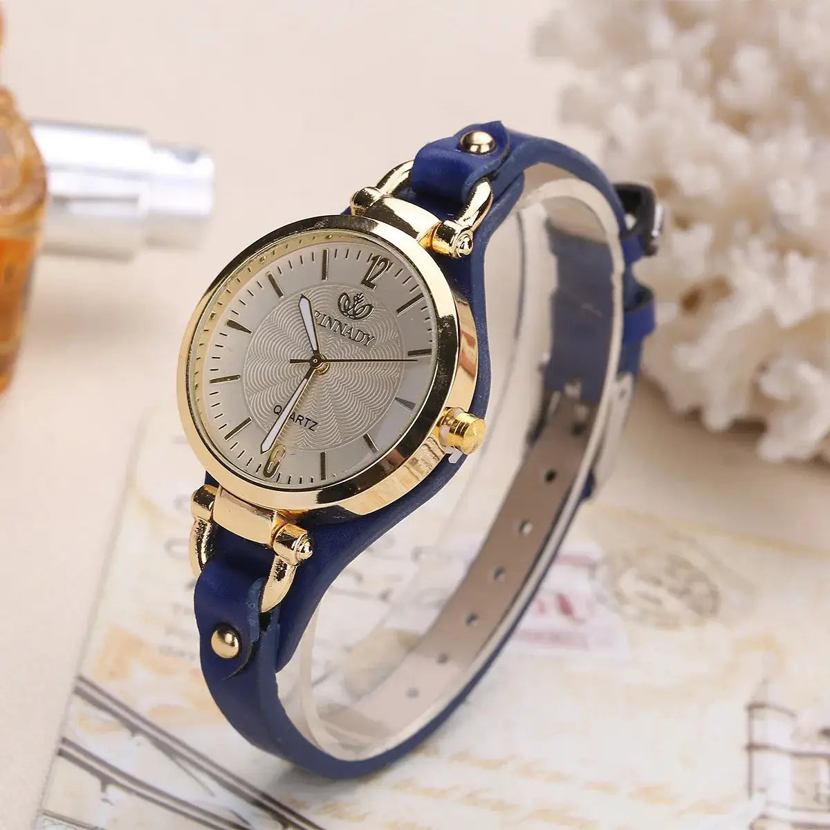 Women's quartz watch with blue leather strap and gold-tone case, minimalist design