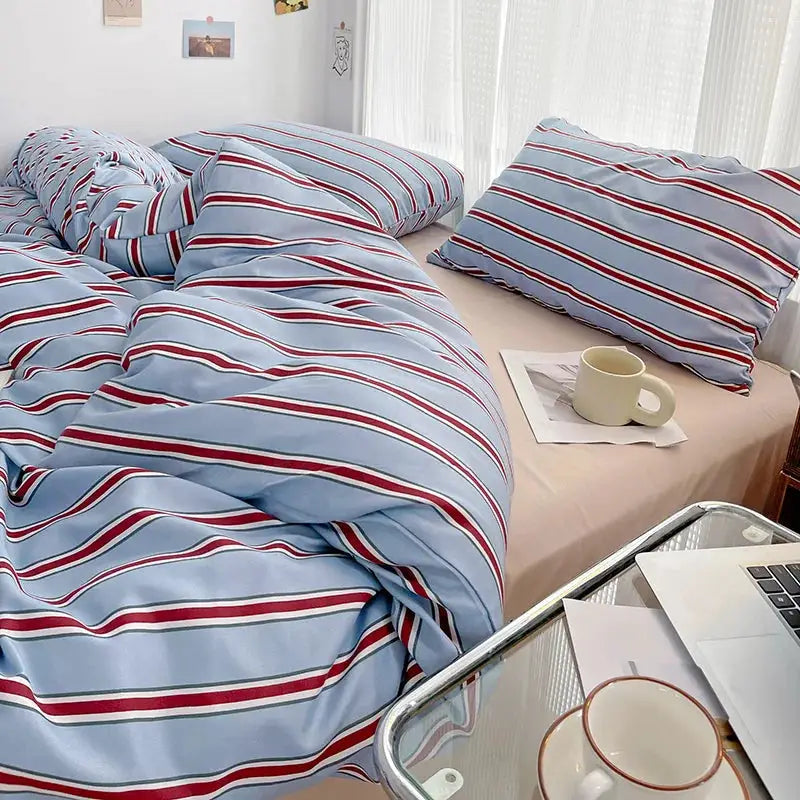Red and blue striped duvet cover with washed cotton four-piece sheet set on bed