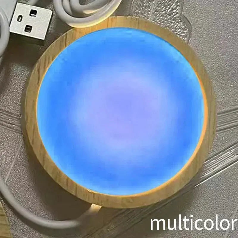 Round wooden LED night light base with multicolor glow and attached USB cable