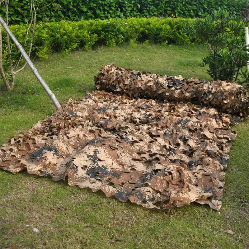 Desert camouflage net in tan and brown with black accents spread on grass for hunting or garden gazebo use