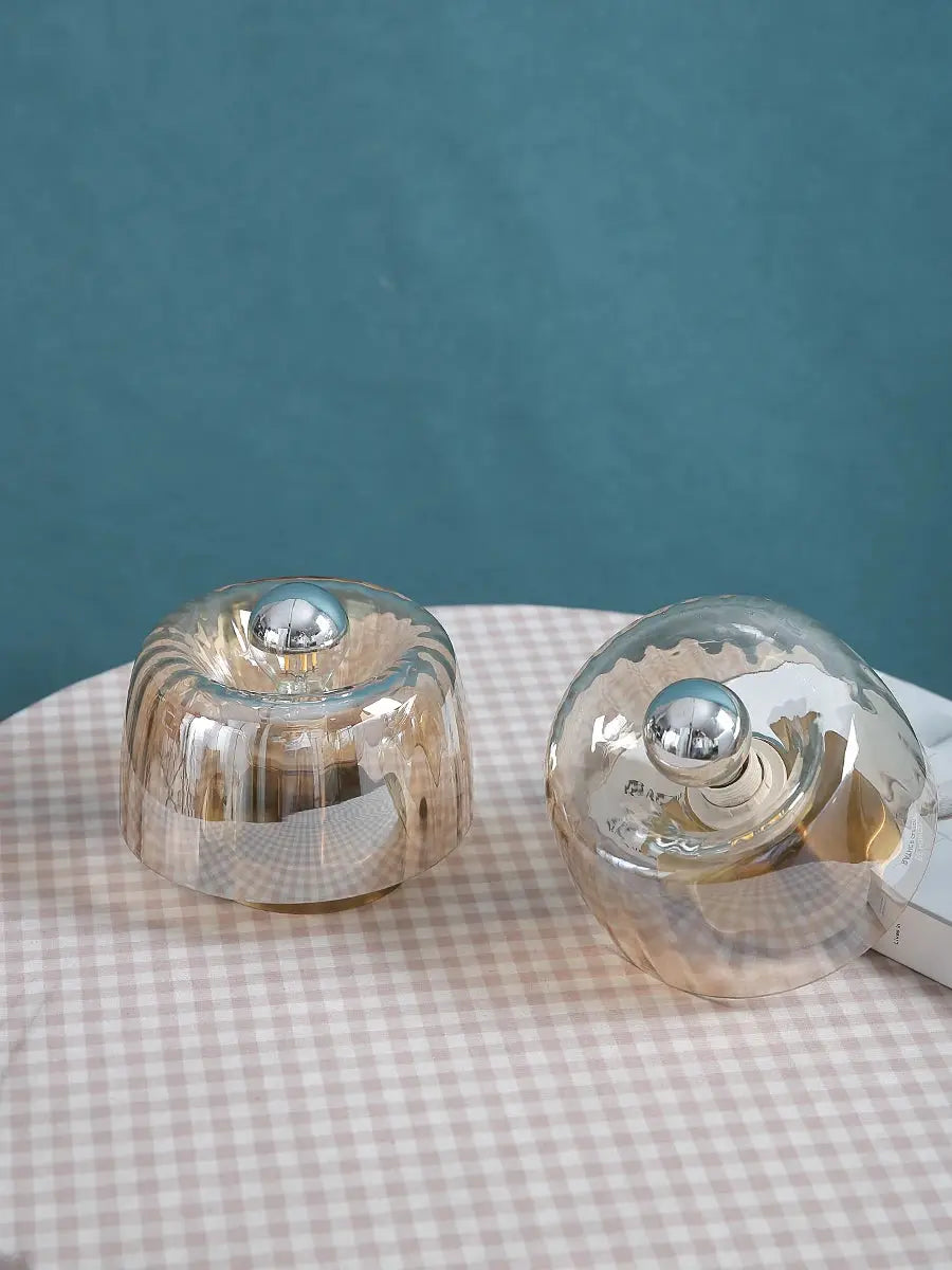 LED glass bubble lamps, pair of transparent domes with chrome spheres on a pink gingham table