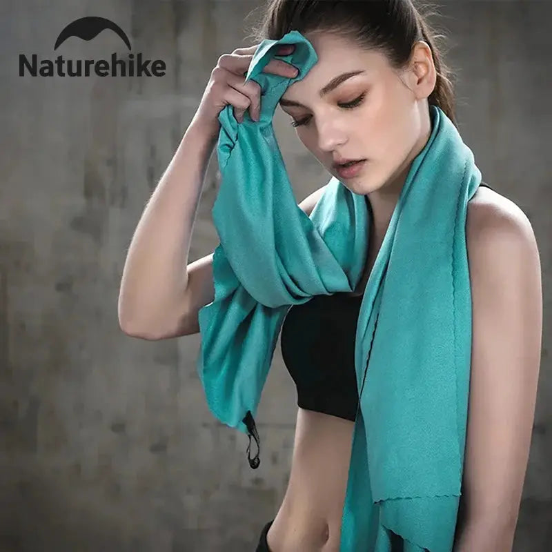 Naturehike quick-drying microfiber towel in turquoise, draped over a model.
