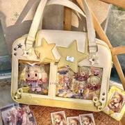 Beige Y2K star Ita bag with two transparent front pockets and yellow star patches.