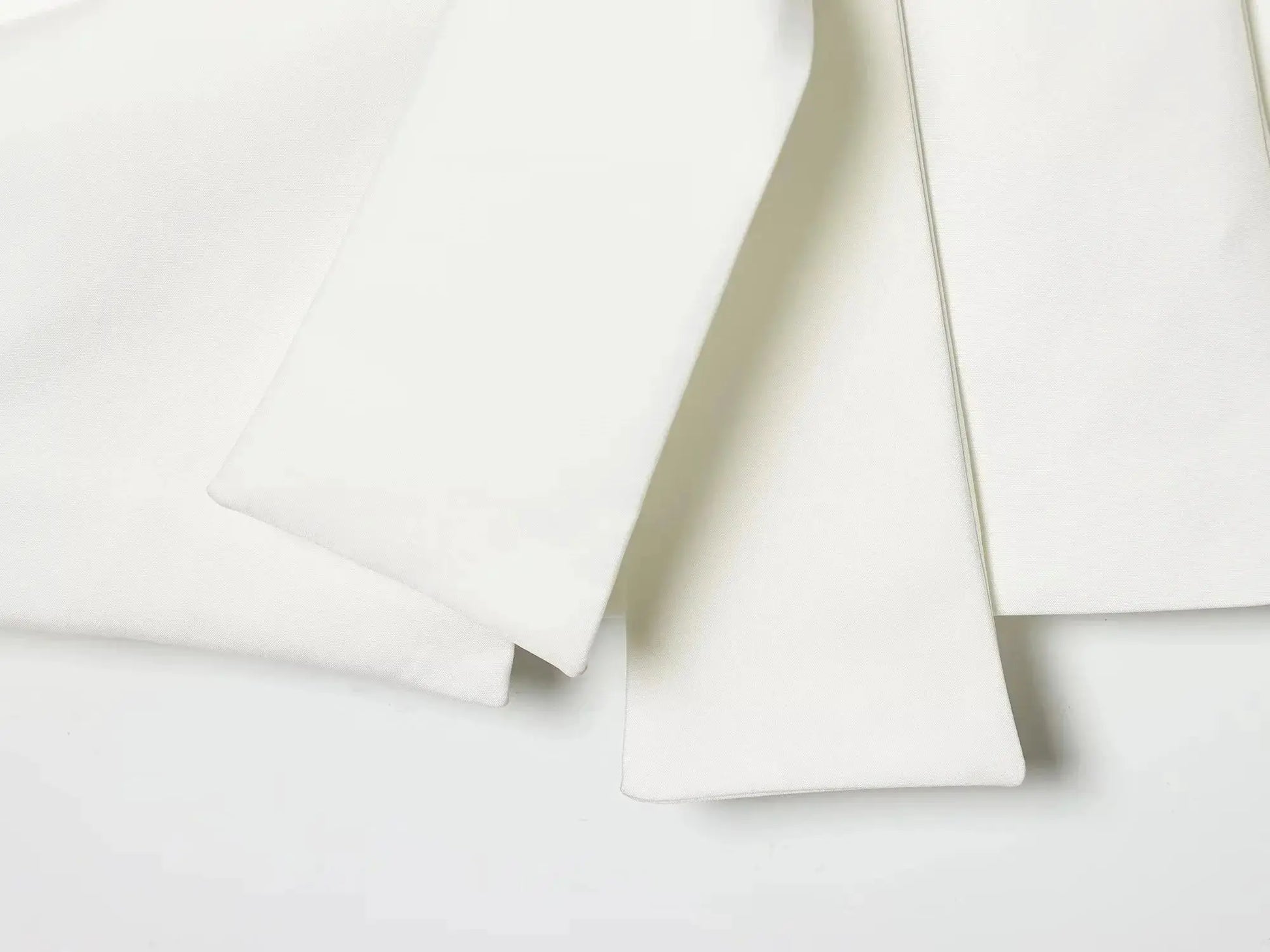 White fabric swatches folded in layers, showing smooth texture and clean edges