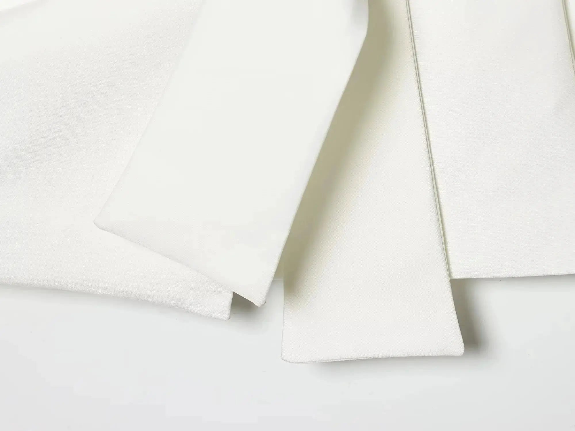 White fabric swatches folded in layers, showing smooth texture and clean edges