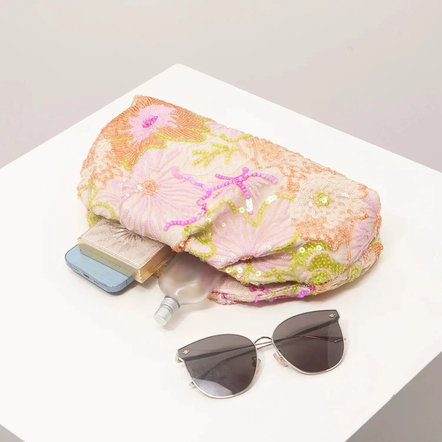 Clutch bag with pastel pink floral embroidery and sequins; peach and lime accents.