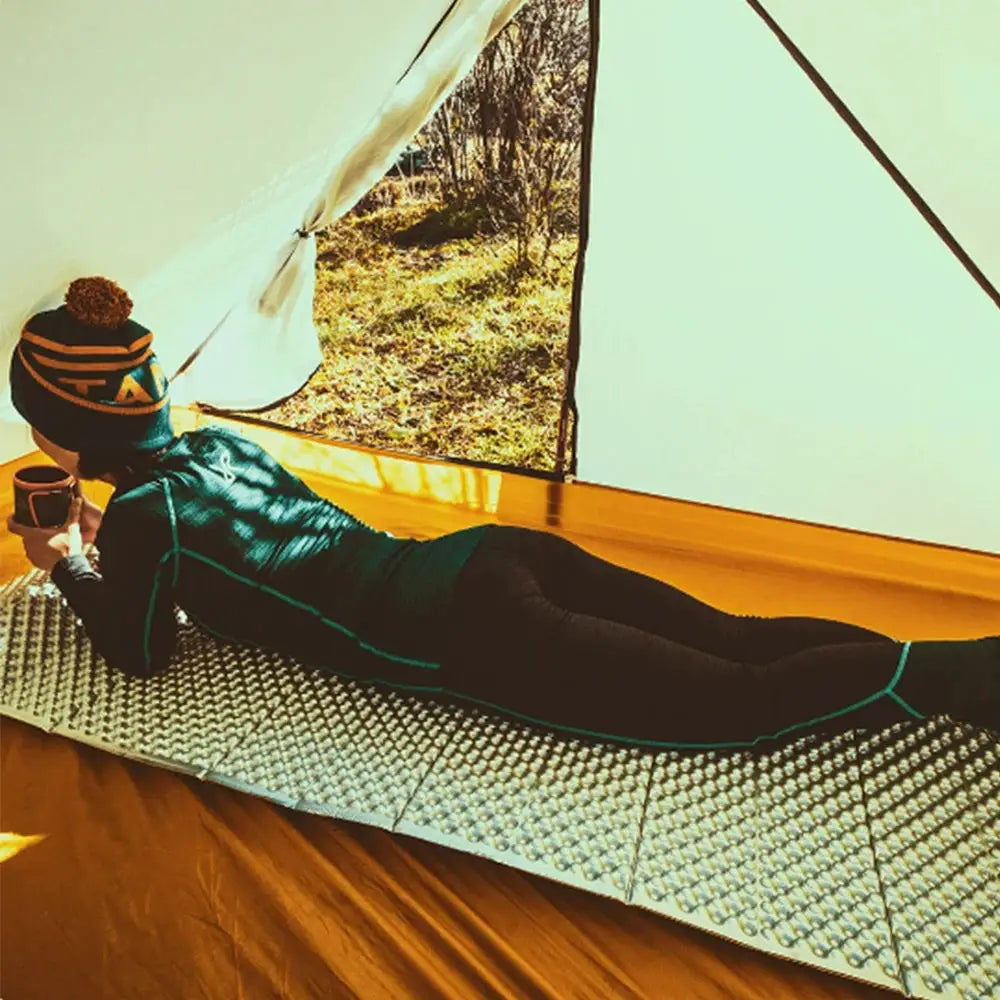 Ultralight folding egg-nest camping pad with bubble-grid foam surface and blue trim