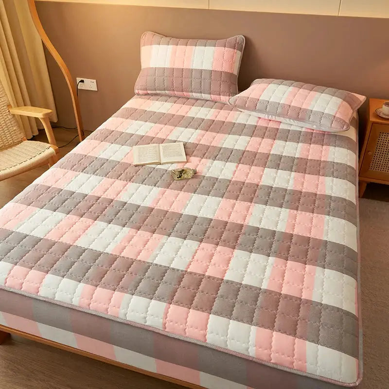 Simples Market quilted plaid mattress cover with two pink-gray pillows on a bed