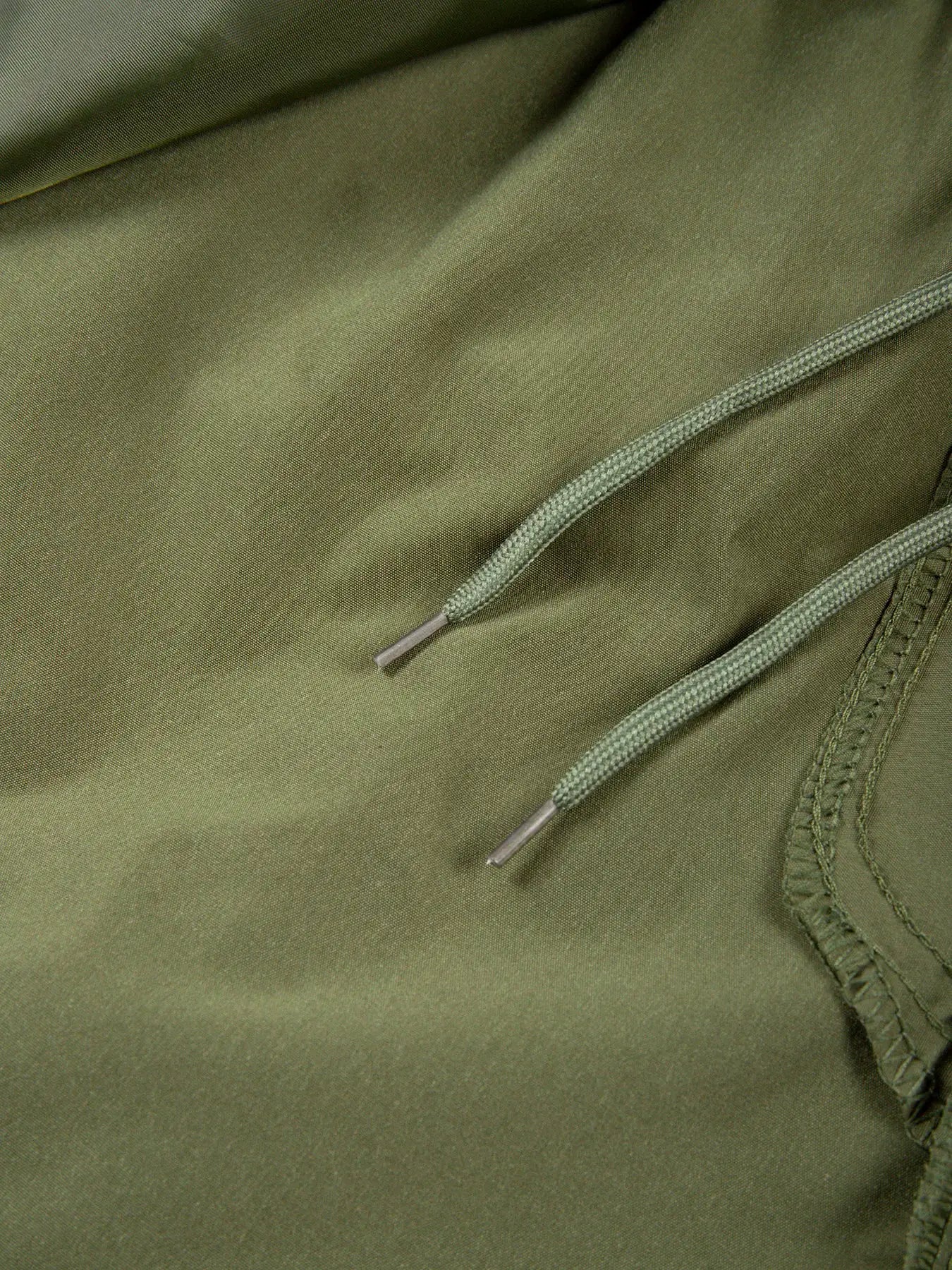 Men's cargo shorts in olive green with drawstring detail and zipper seam