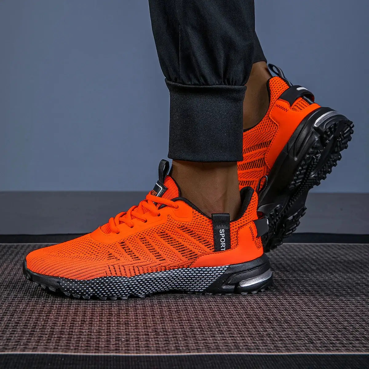 Men's orange running shoes with breathable knit mesh, lace-up closure and rugged black rubber outsole.