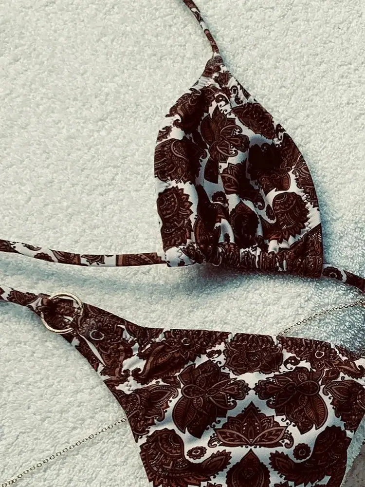Bikini set with triangle top and thong bottoms in brown paisley print, chain accents.