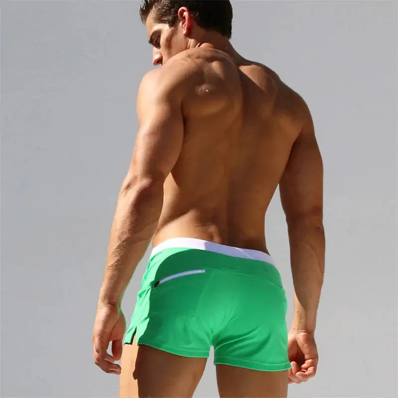 Men's green swim shorts with white waistband and back zip pocket, quick-drying trunks
