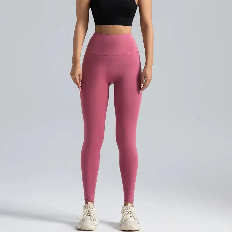 Women's pink high-waisted leggings, full-length athletic pants with a snug fit.