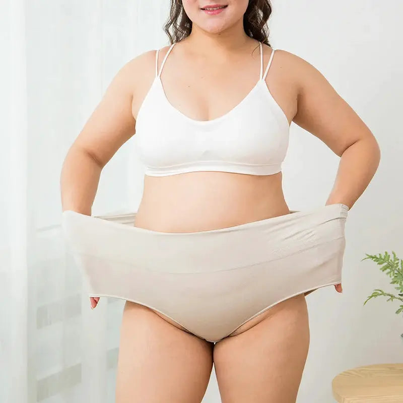 Beige high-waist cotton panties for women (plus size) shown on a model with a white bra.