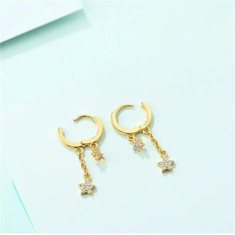 Gold-tone hoop earrings with dangling crystal-star charms, two-piece pair for women