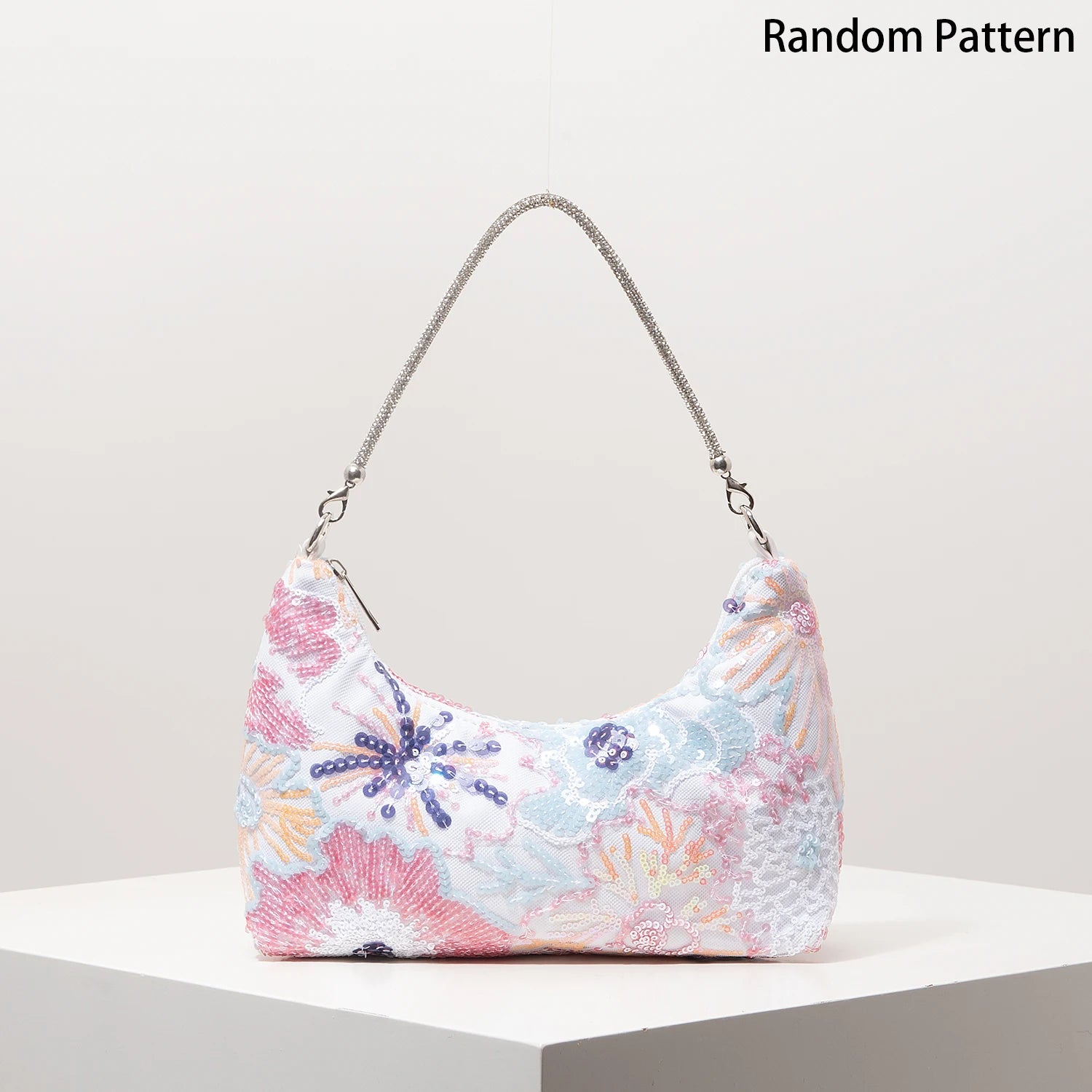 Shoulder bag with pastel floral embroidery and sequin detailing, silver chain strap, decorative pattern.