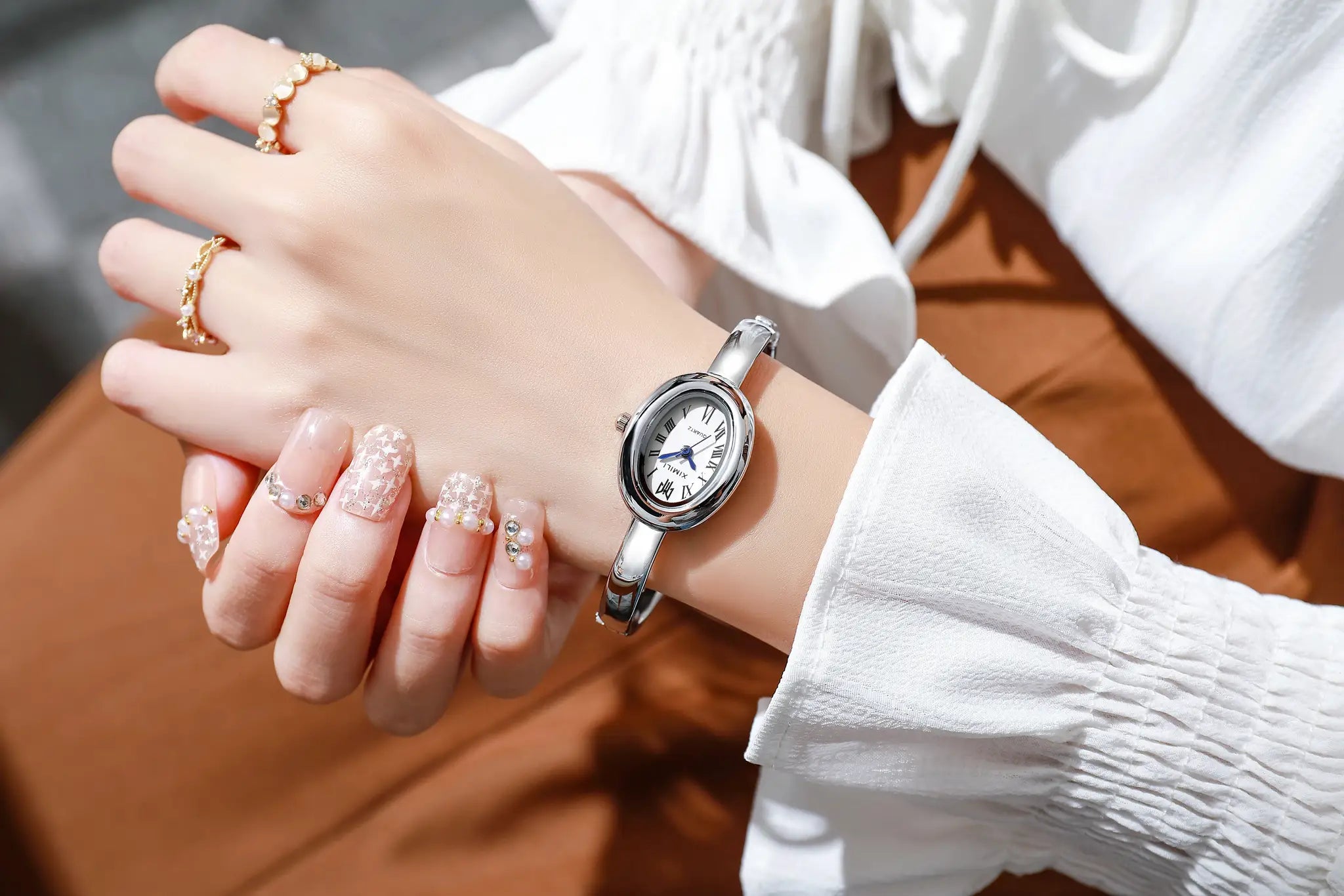 Women's silver stainless-steel quartz wristwatch; waterproof with Roman numeral dial