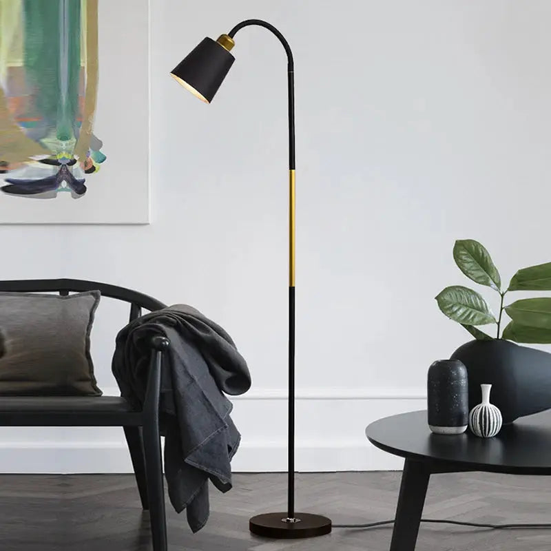 Floor lamp by Simples Market; black wrought-iron stand with brass accents and adjustable LED head