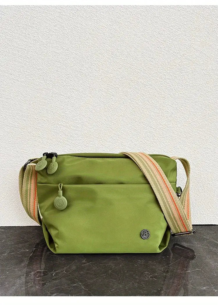 Crossbody bag by Simples Market, olive nylon with adjustable striped strap and zipper closure