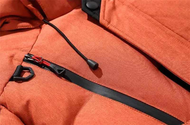 Orange puffer down jacket close-up with black zipper, drawcord, and quilted padding.