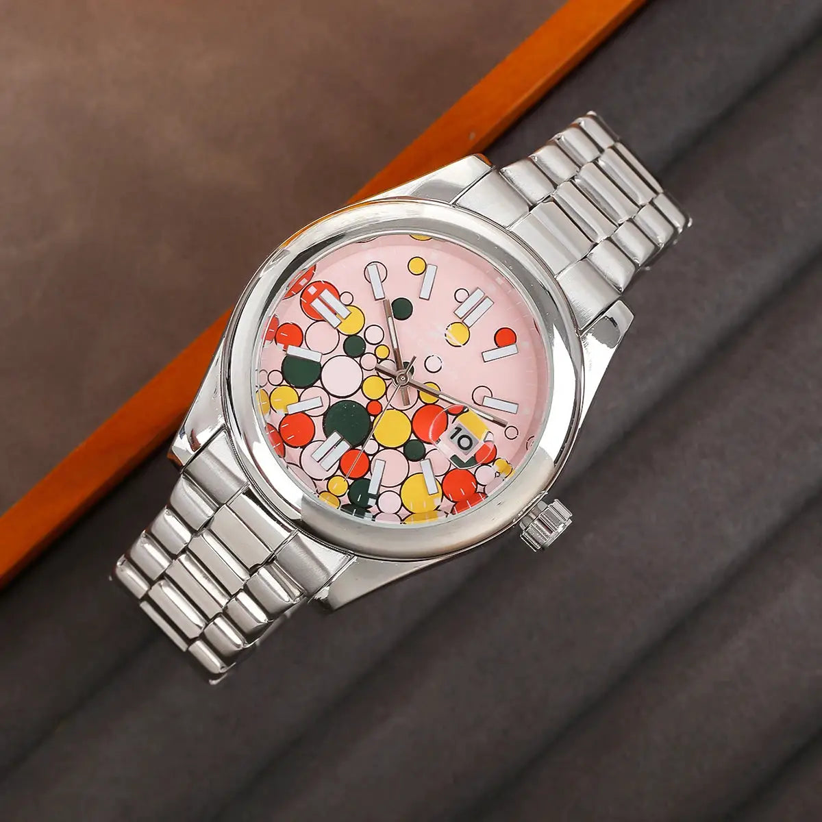Classic men's quartz wristwatch with pink dial, calendar date, and stainless steel band