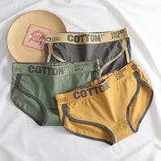 Three pairs of women’s cotton briefs in green, gray, and mustard with KISS branded waistbands.
