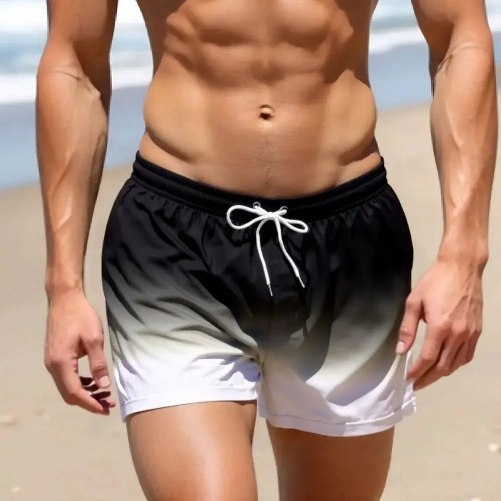 Men's swim shorts with black-to-white gradient and white drawstring at the beach