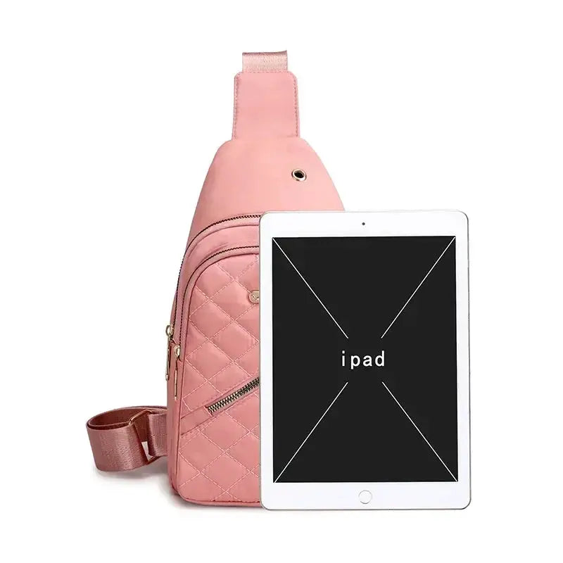 Crossbody pink quilted bag with gold hardware, shown with an iPad for scale