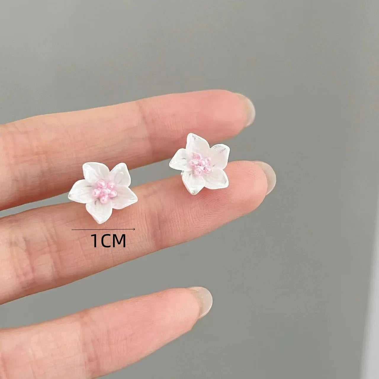 Pair of white camellia flower stud earrings for women, pink centers, about 1 cm each.