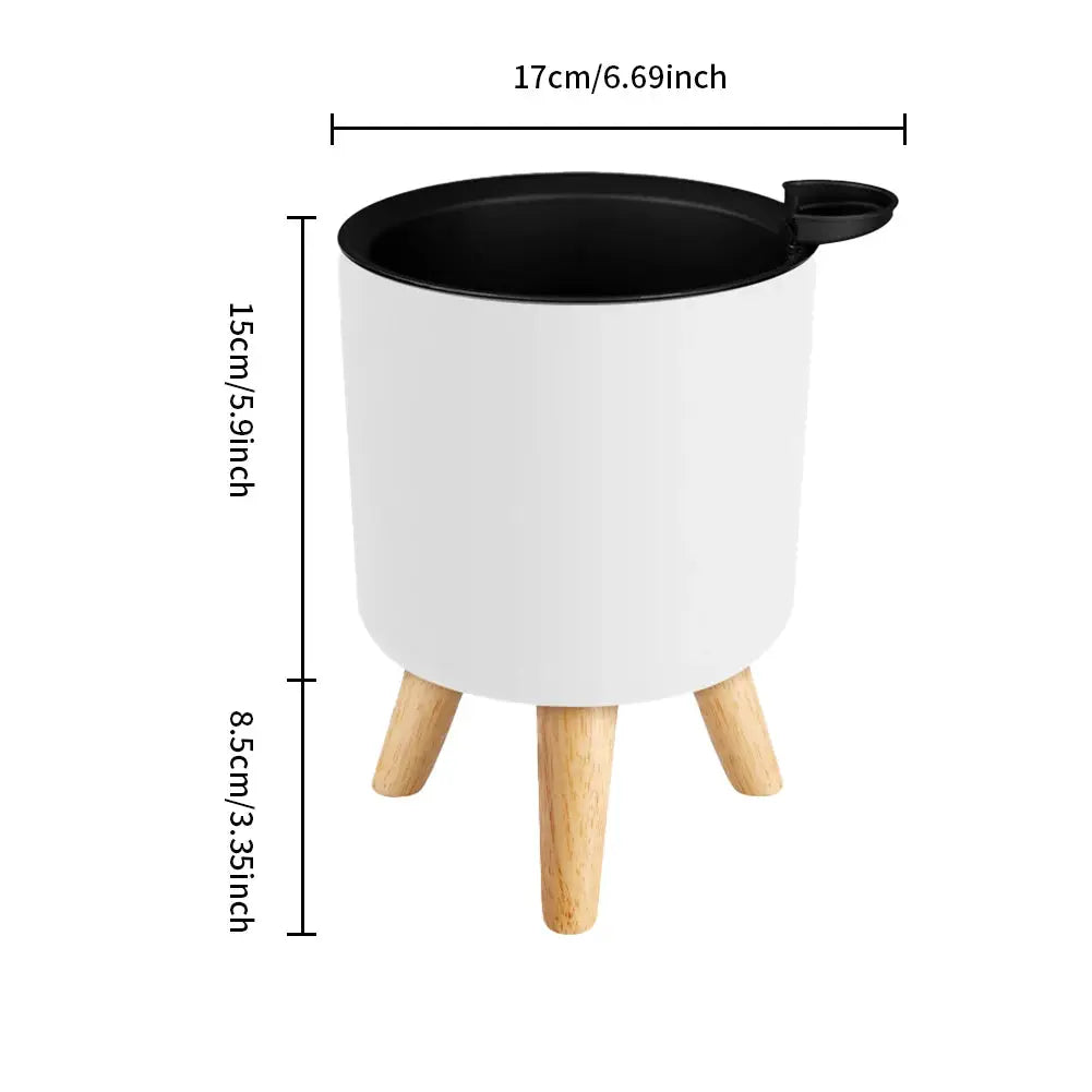Simples Market floor-standing round plant pot with wooden legs, white body, black rim, self-watering drainage.