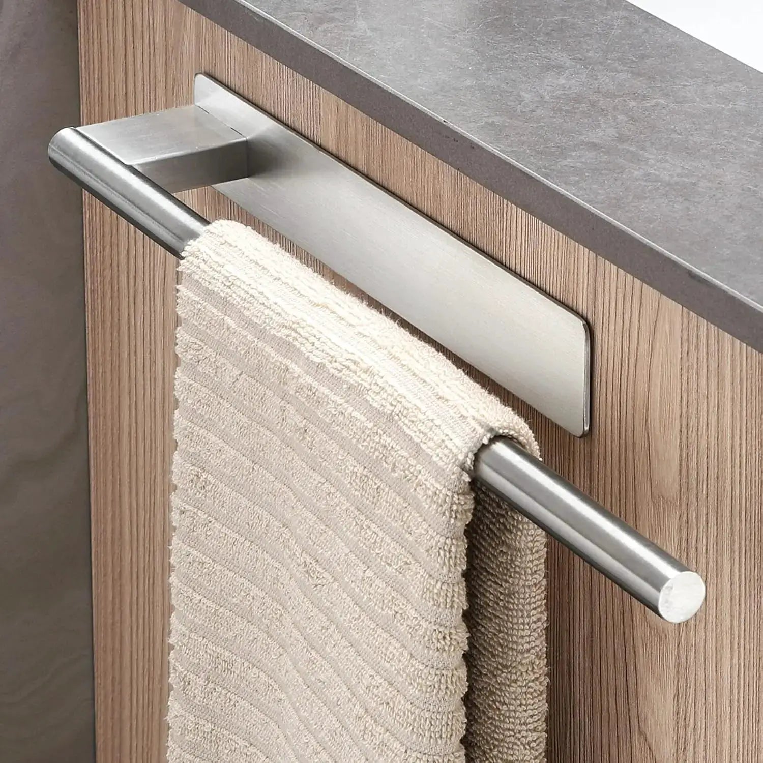 Bathroom towel bar with no-drill adhesive mount on wood cabinet; stainless steel finish with beige towel.