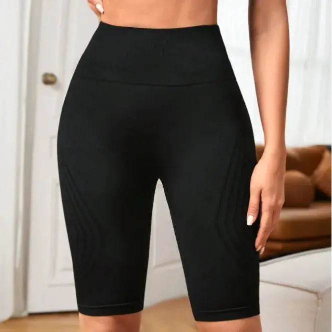 High-waisted seamless yoga shorts for women, black knit fabric with curved side panel lines.