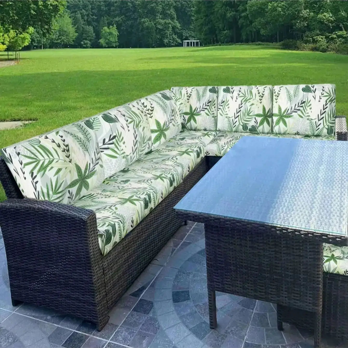 Outdoor tropical leaf print sofa cushion covers by Simples Market on wicker sectional with a glass patio table