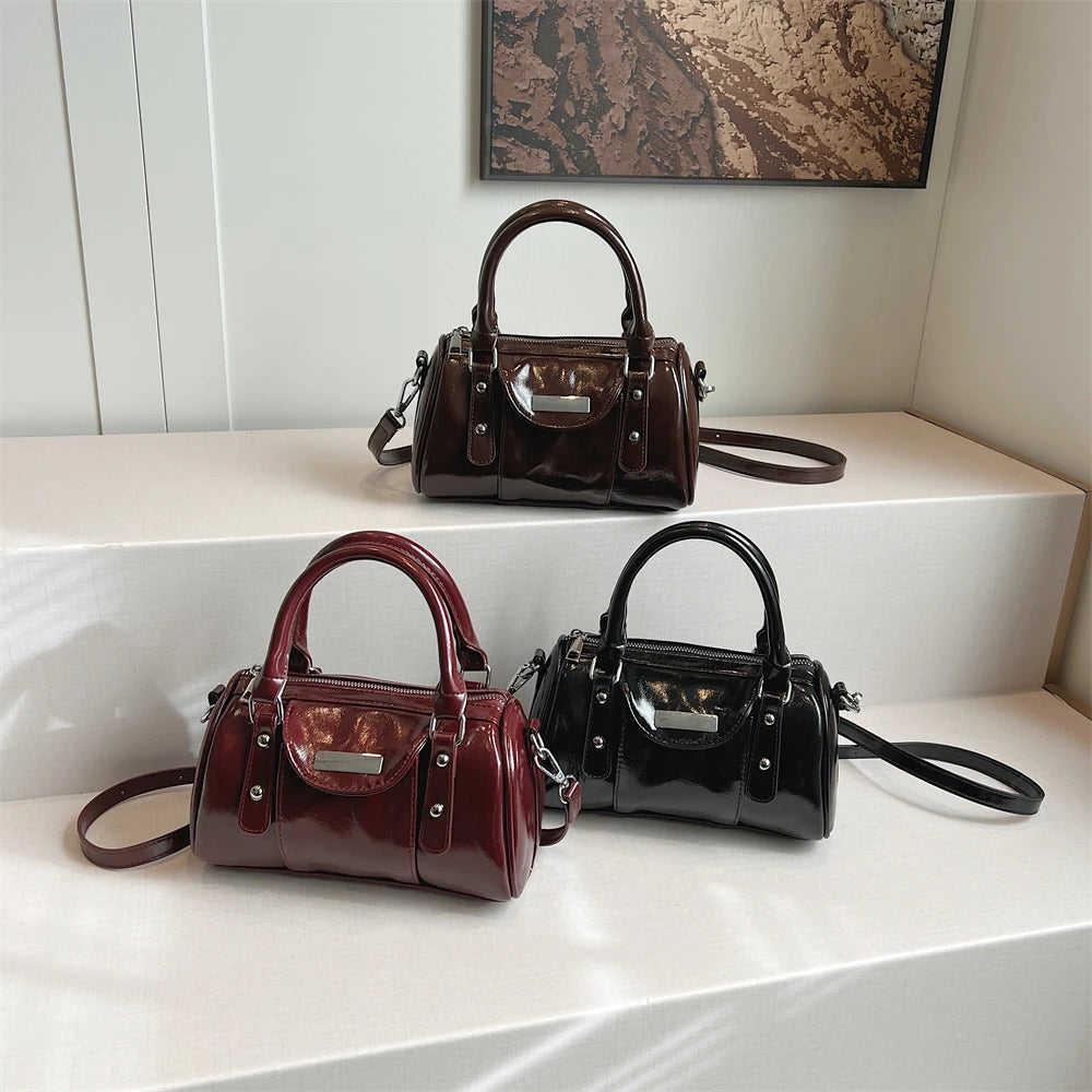 Three mini top-handle bags in brown, burgundy and black patent PU leather