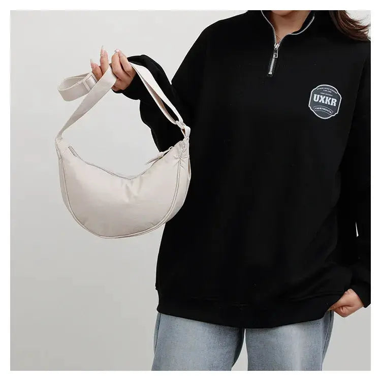Nylon crossbody bag in cream, crescent dumpling shape with zipper, large capacity.