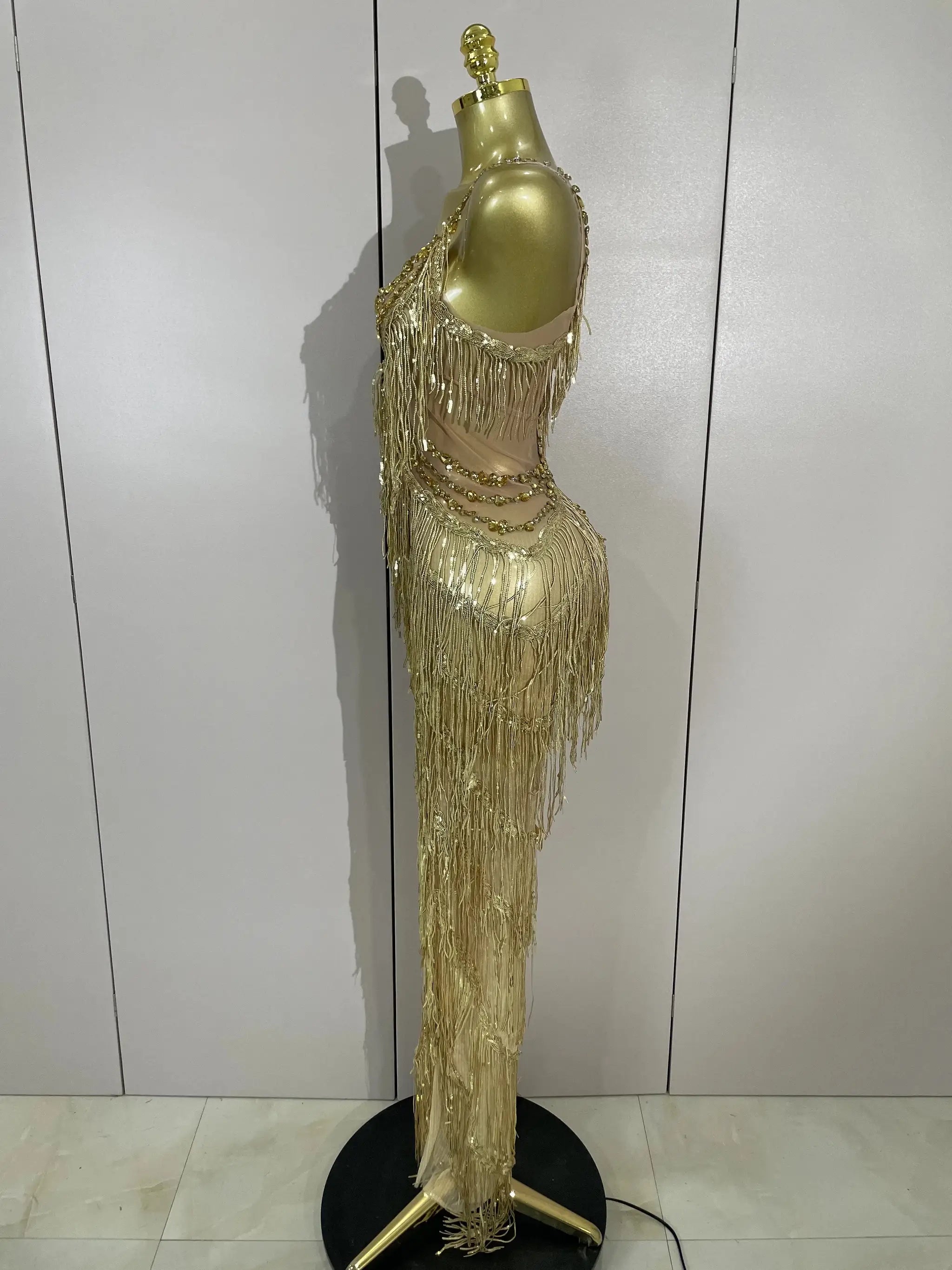 Jumpsuit with gold sequined fringe on mannequin, long tassels for stage performances