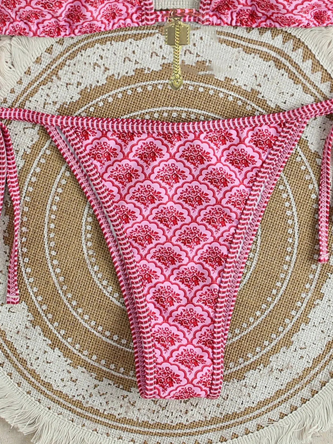 Bikini bottoms in pink floral print with side tie strings; Brazilian-cut style