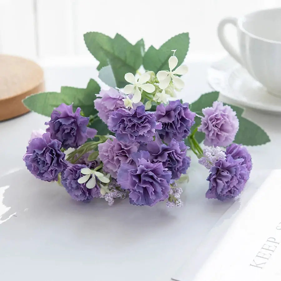 Simples Market artificial purple carnation bouquet with green leaves and white filler blooms