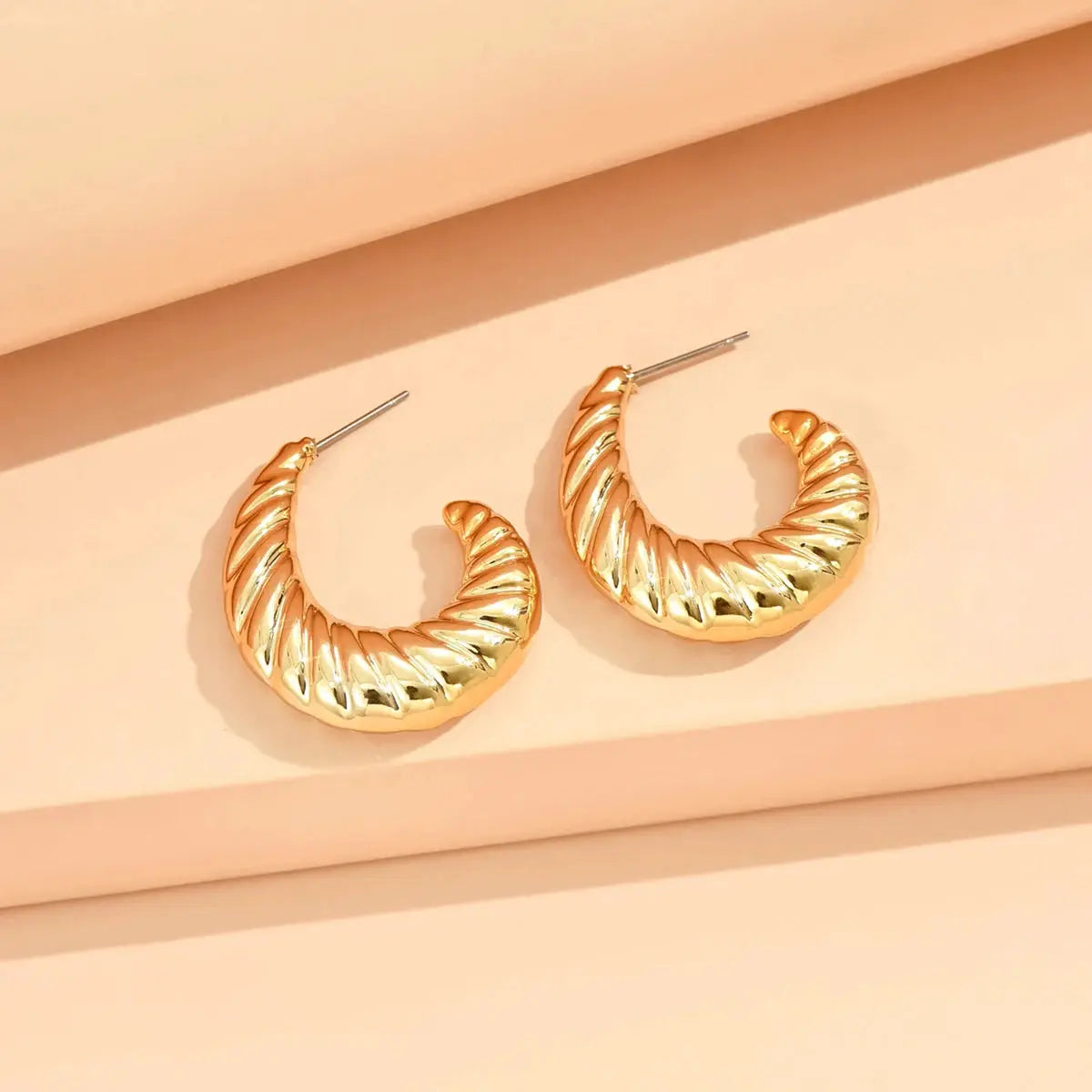 Gold-tone twisted hoop earrings with ribbed texture, pair
