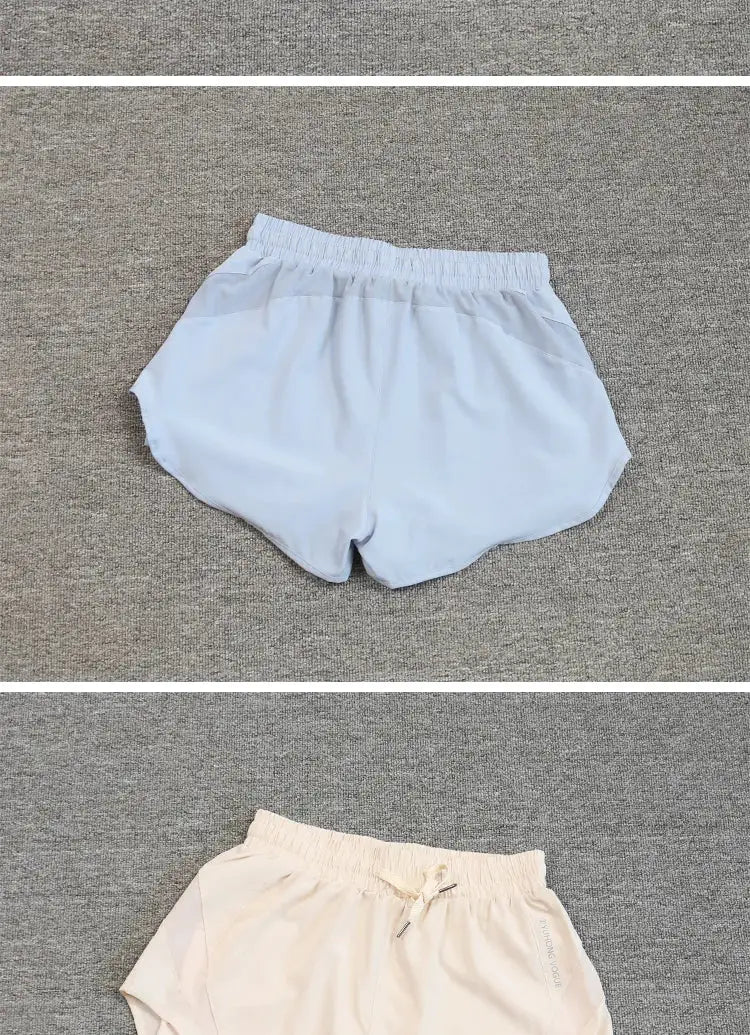 Two women's running shorts in light blue and beige with elastic waist and breathable quick-drying fabric.